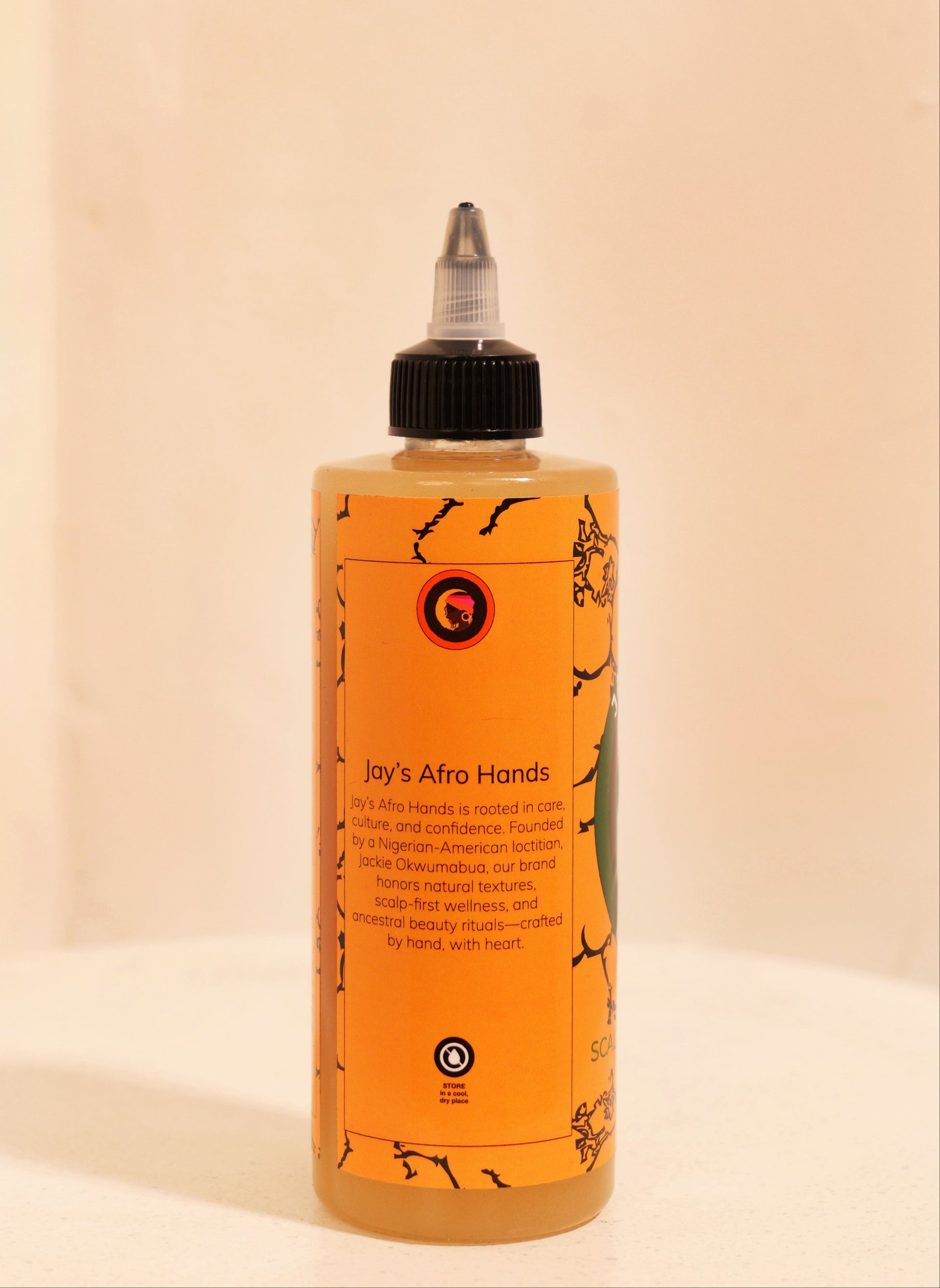 Bottle of 'Jay's Afro Hands' product on a beige background